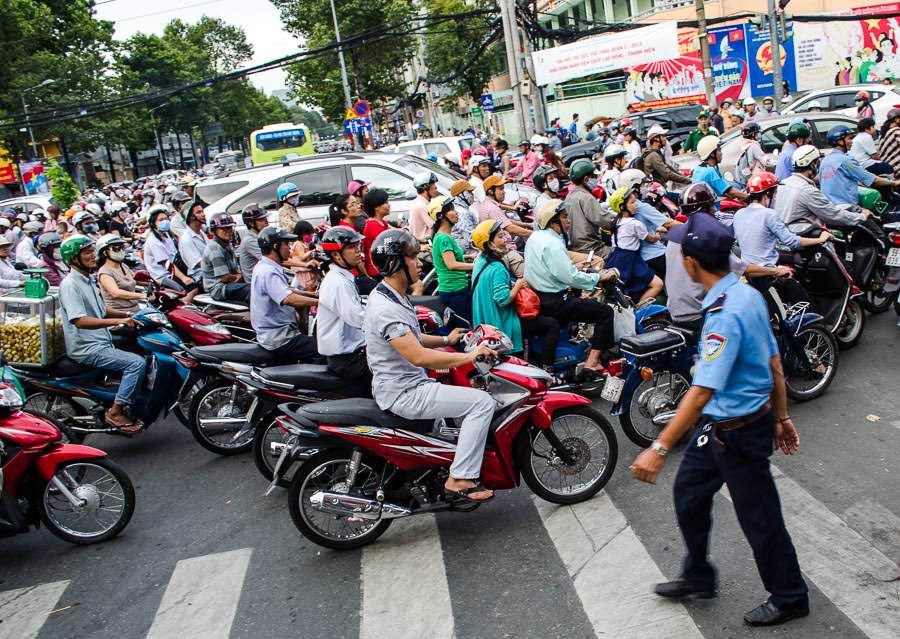 A cluster of motorbikes crossing a major intersection in Ho Chi Minh City, Vietnam.